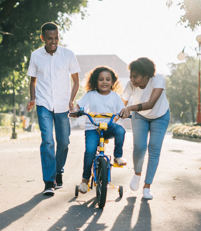 Family learning to ride bike